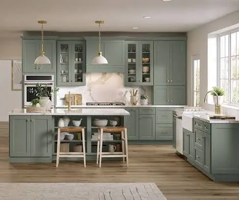Sage green shaker kitchen cabinets with a marble-look backsplash