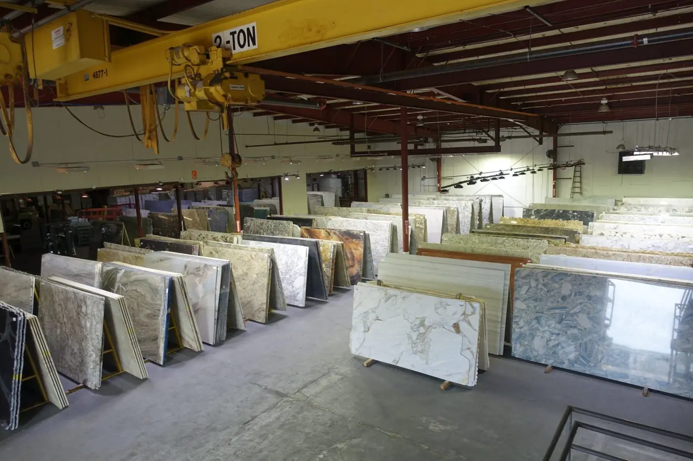 Rows of granite, marble and quartzite slabs under the crane in NSG's Stafford warehouse